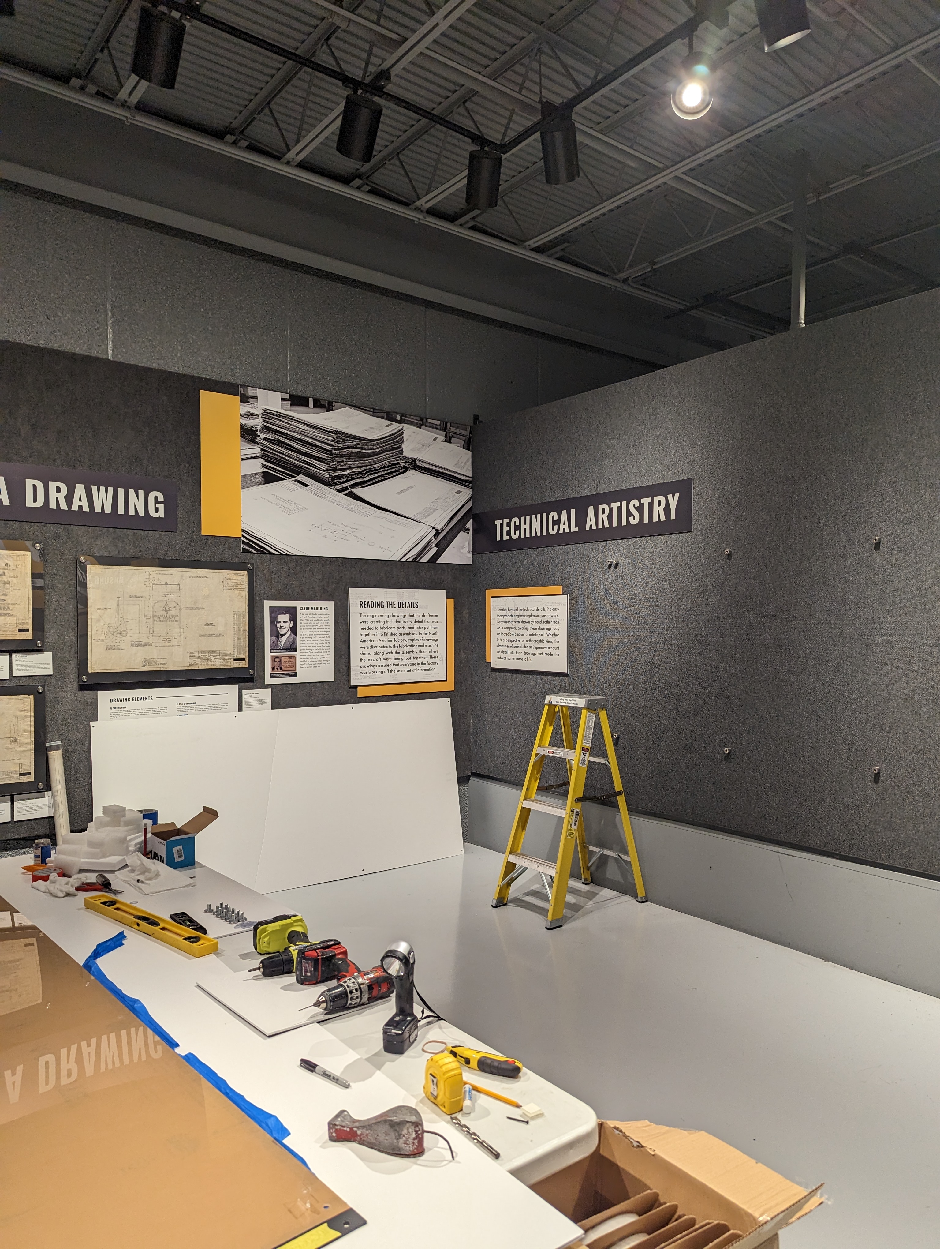 The exhibit begins to take shape as drawings and text panels are hung.
